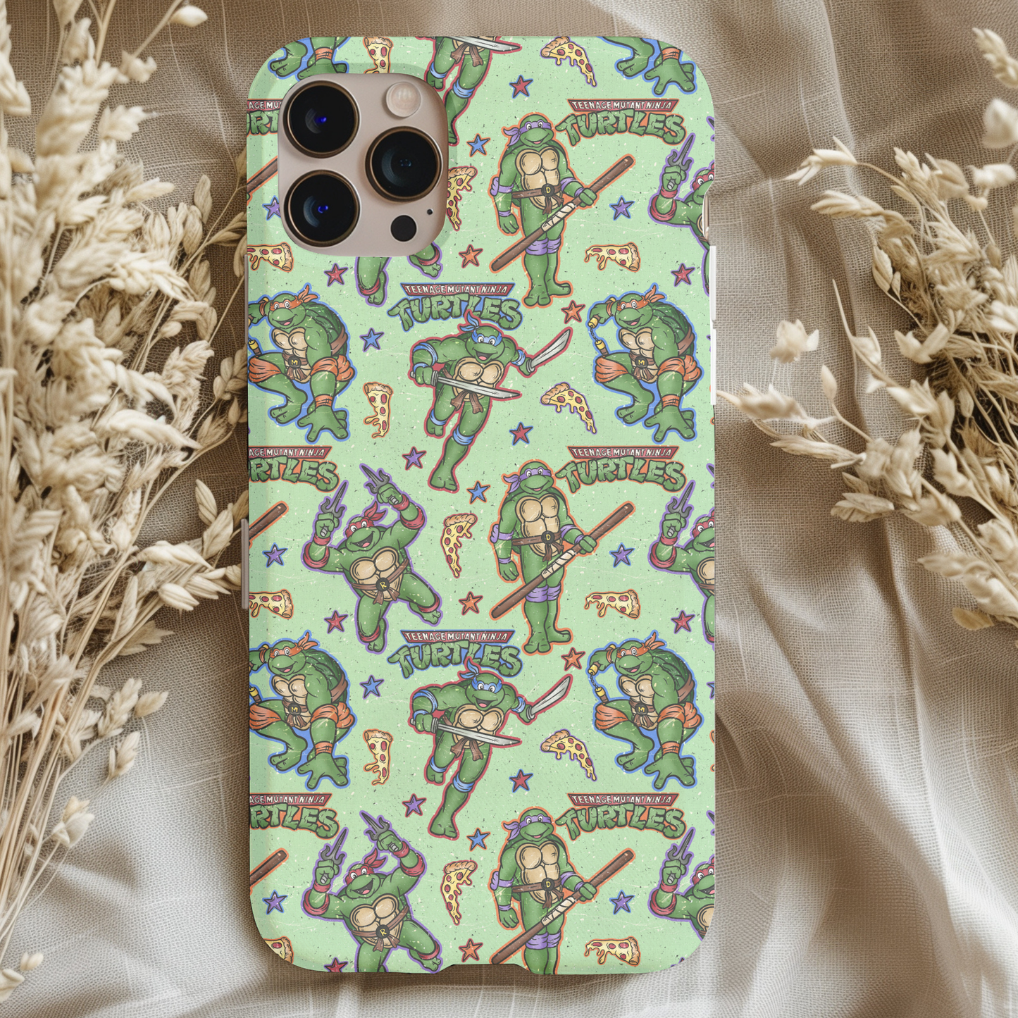 Teenage Mutant Ninja Turtles Phone Case featuring colorful cartoon turtles and pizza slices on a light green background