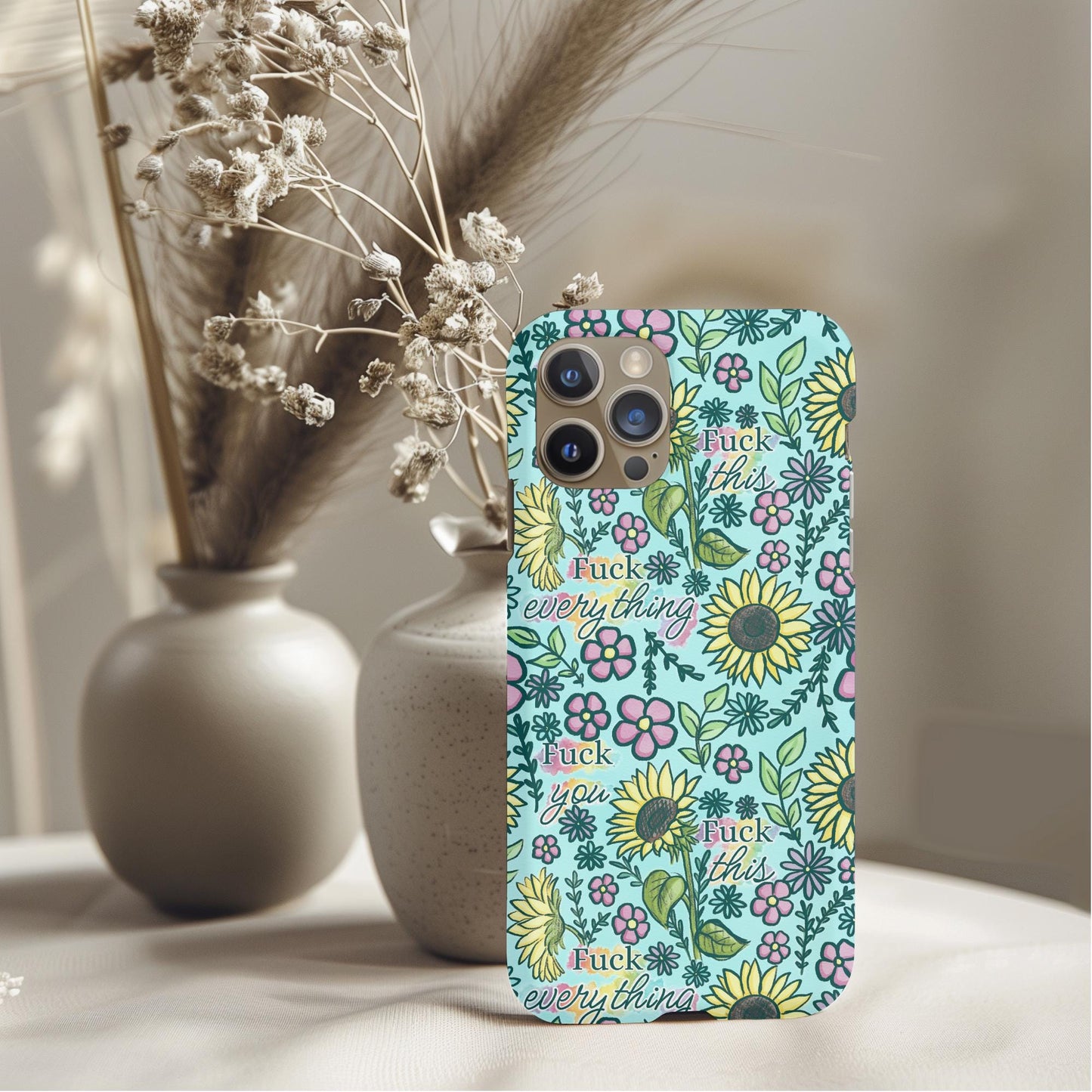 Floral Fck Everything Floral Phone Case with colorful flowers and sunflowers in a light blue background on a phone.