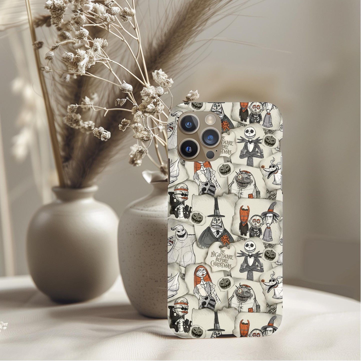 Nightmare Before Christmas Scraps Phone Case featuring whimsical sketches of characters in a soft neutral setting.