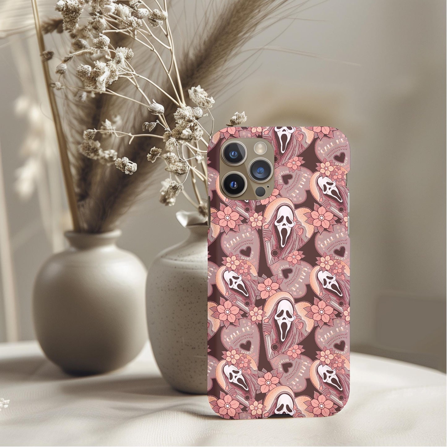 Ghostface Call Me Planchette Phone Case featuring a pattern of ghost masks and floral elements on a soft background