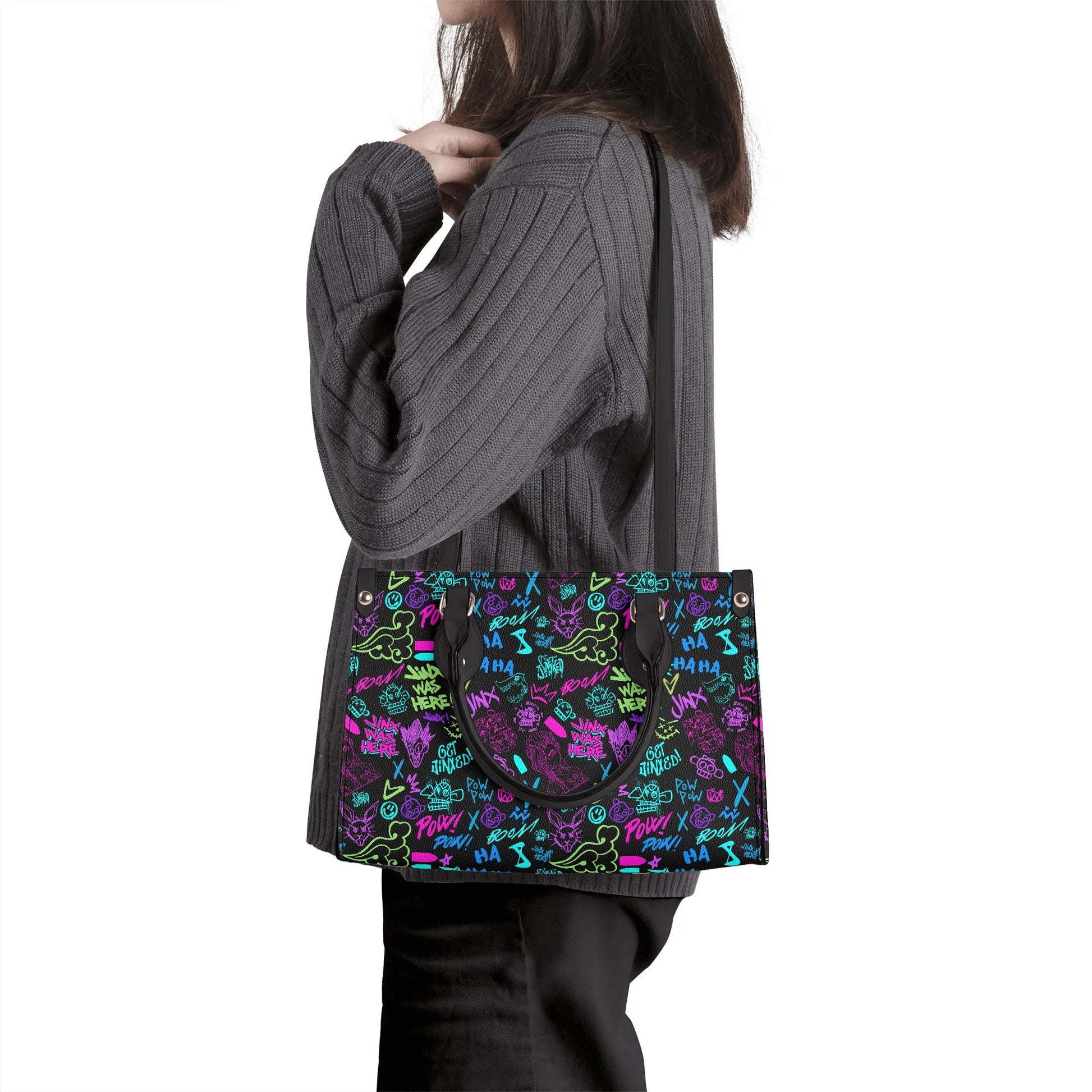 Woman carrying colorful Arcane Jinx Graffiti Leather Handbag with vibrant street art patterns on black background
