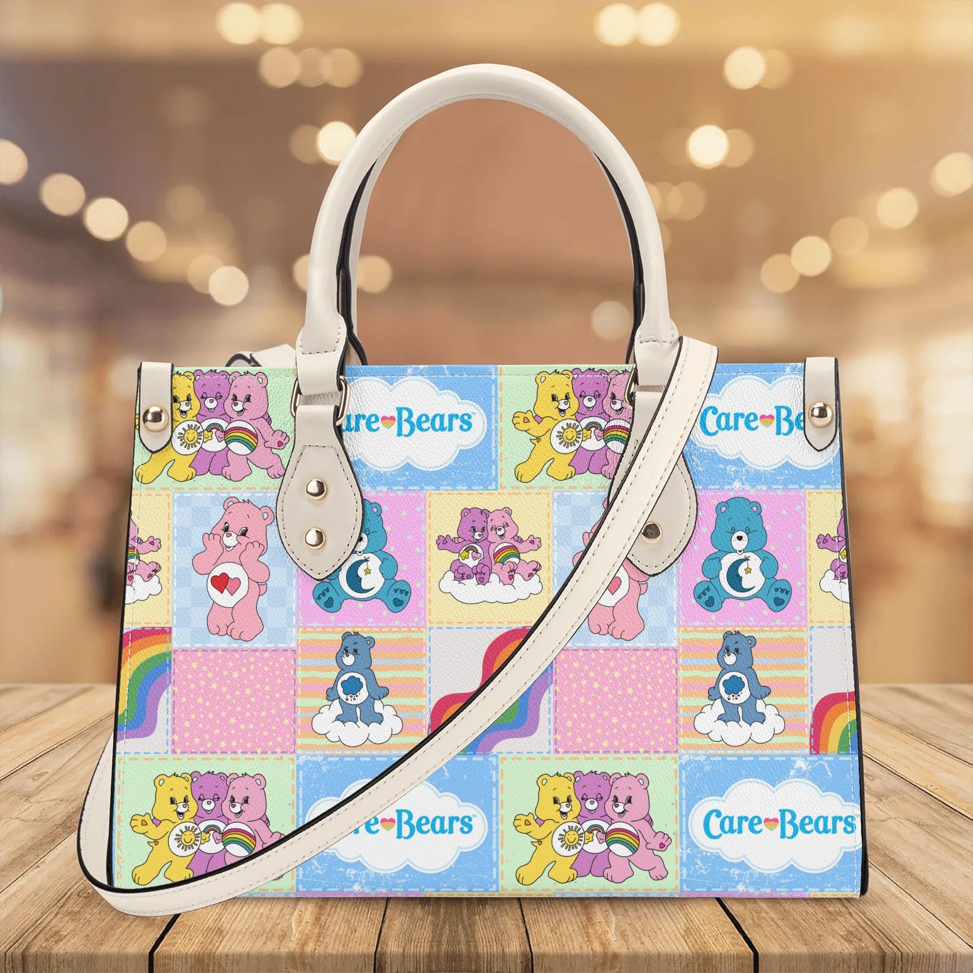 Nostalgic Care Bears Patchwork Leather Handbag featuring colorful Care Bears and rainbow designs with white handles and strap