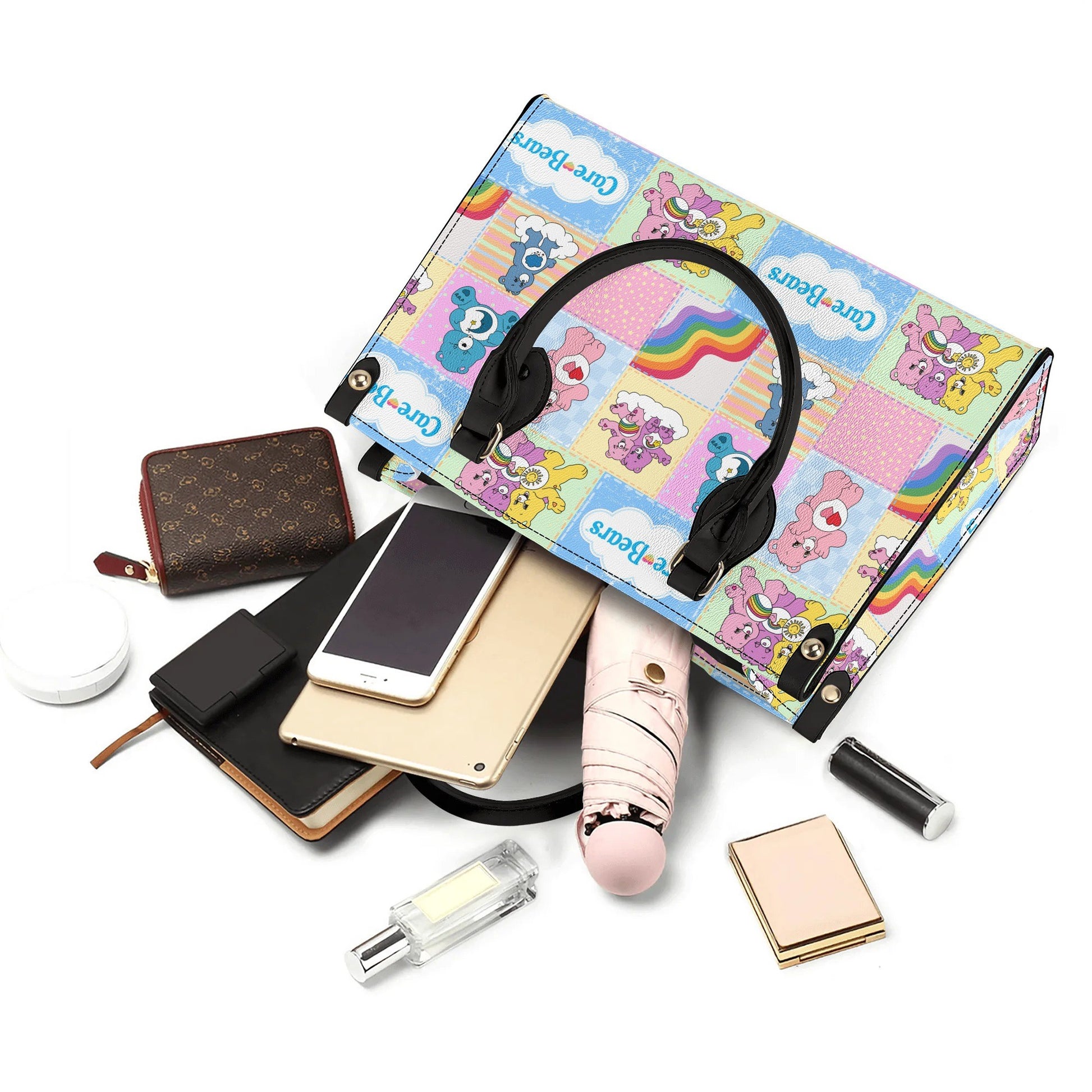 Nostalgic Care Bears Patchwork Leather Handbag with colorful Care Bears design and black handles displayed with everyday essentials