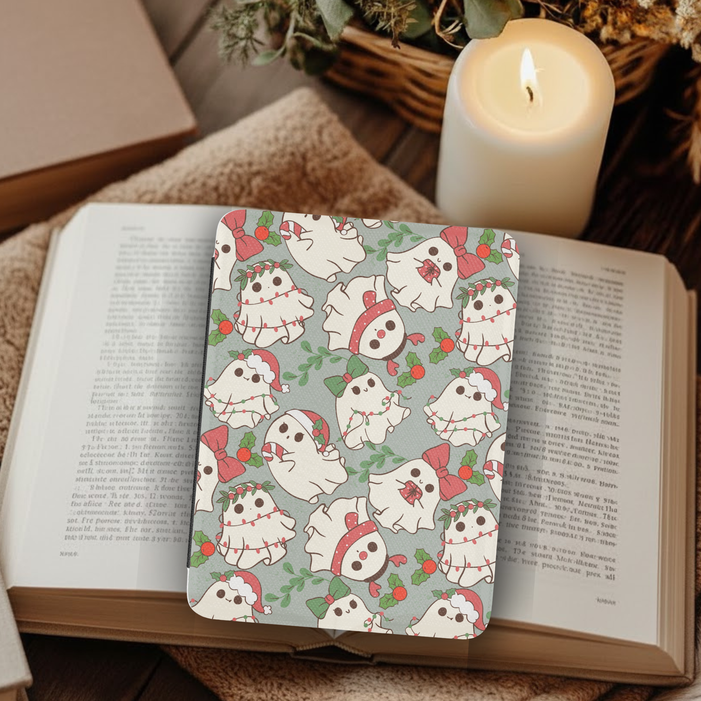 Christmas Ghosties Leather Kindle Case with Hand Strap featuring festive ghost designs on a cozy reading setup with candlelight.