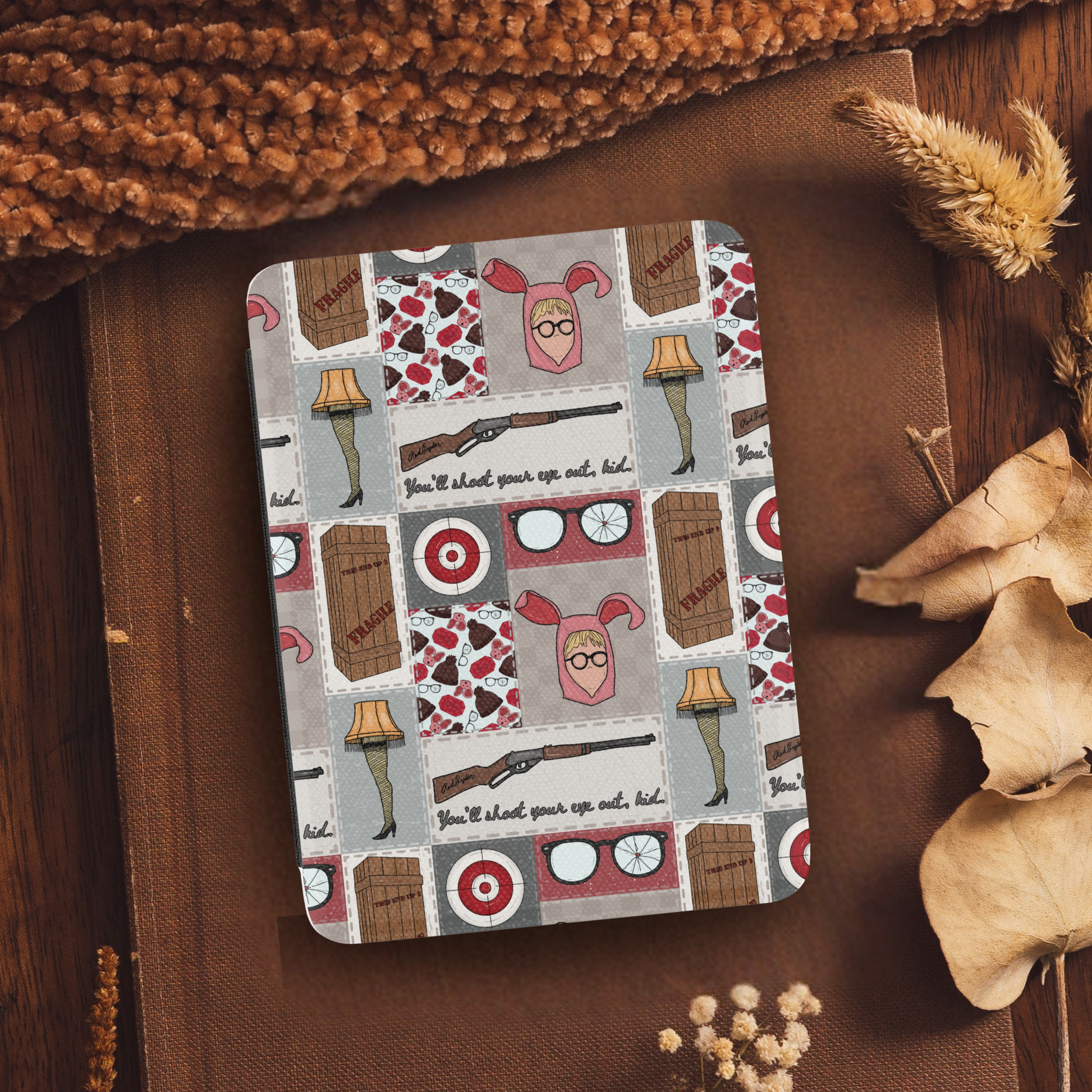 A Christmas Story Patchwork Leather Kindle Case with Hand Strap featuring festive movie-themed illustrations on a cozy background