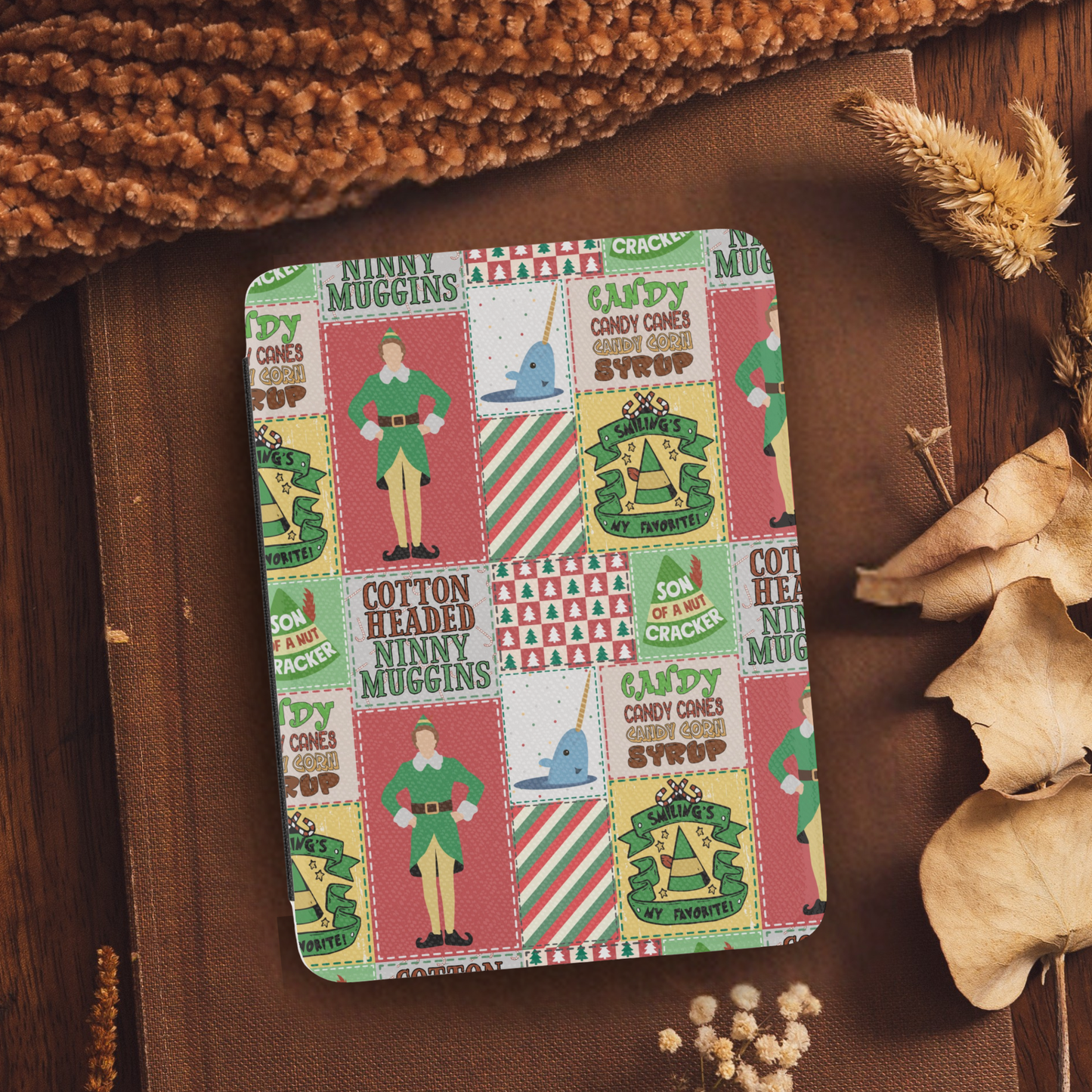 Christmas Elf Patchwork Leather Kindle Case with Hand Strap featuring festive holiday patchwork design on a cozy brown fabric background