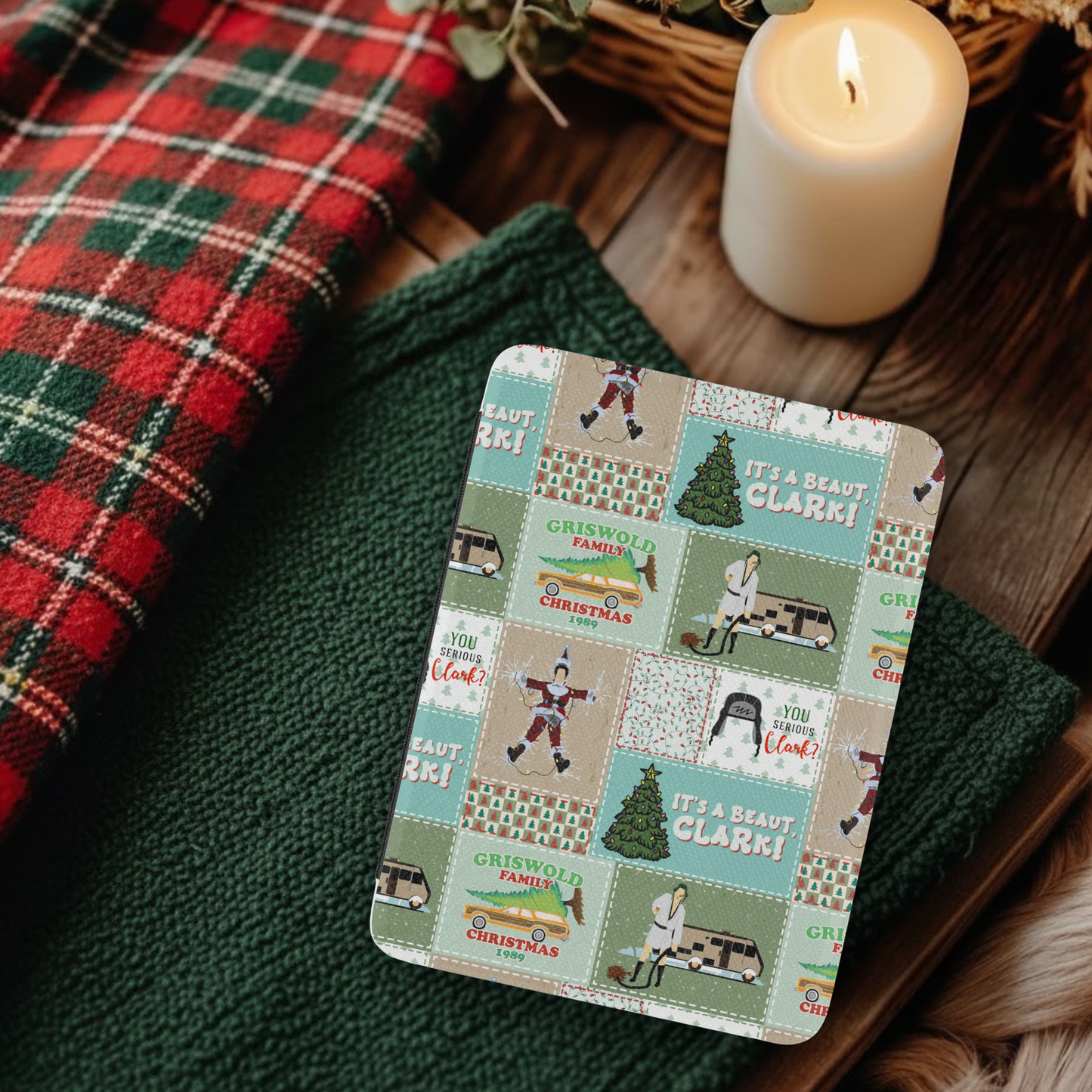 Christmas Vacation Patchwork Leather Kindle Case with Hand Strap on cozy fabric next to lit candle and plaid textile
