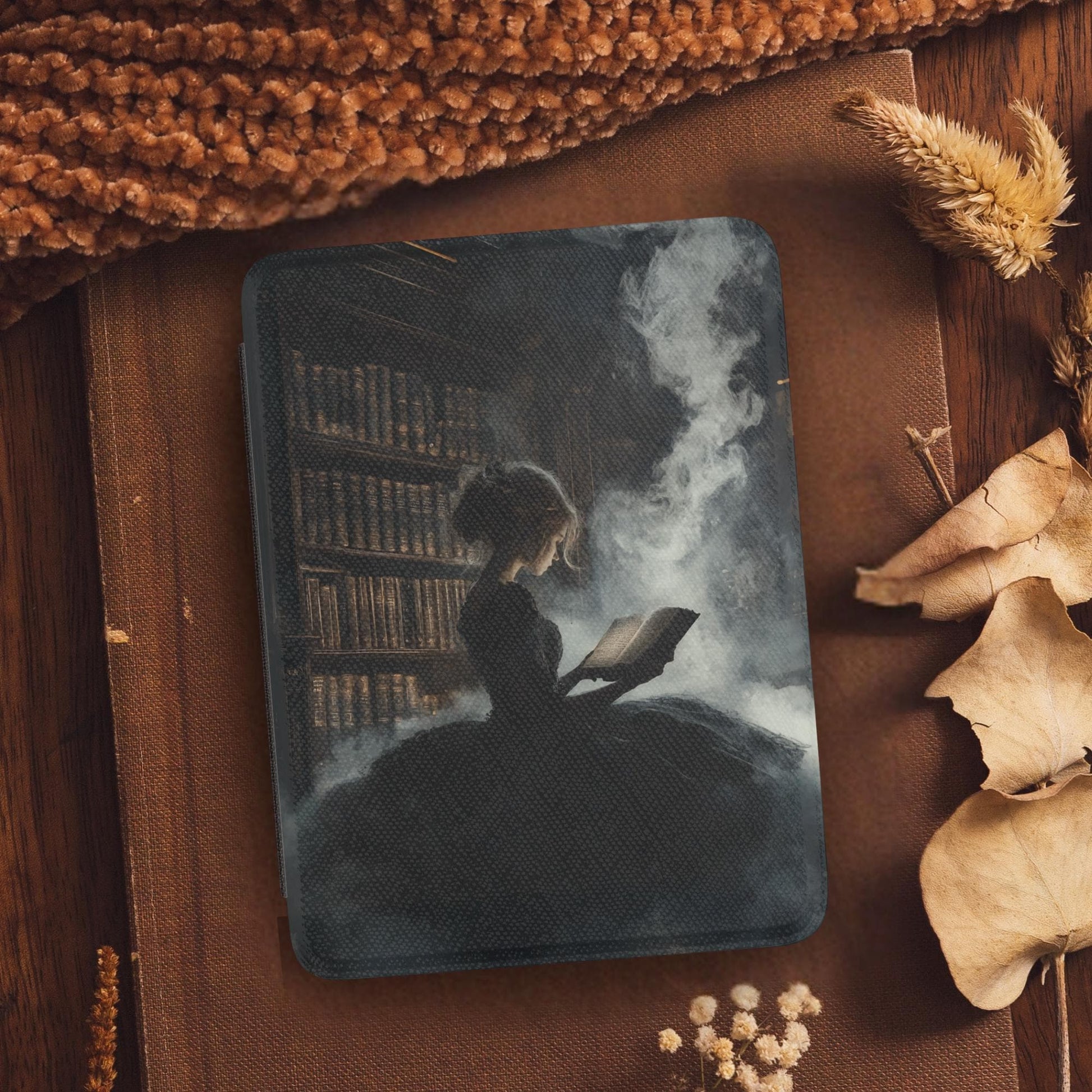 Book Lover Girl Leather Kindle Case with Hand Strap featuring a girl reading amid smoky library background on cozy surface